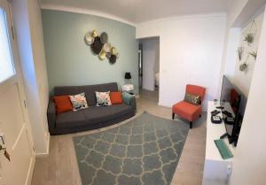 a living room with a couch and a chair at Friends Place in Praia da Vitória
