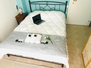 a bed with a laptop and two towels on it at Aegina luxury apartments in Aegina Town