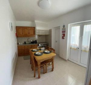 una pequeña cocina con mesa de madera y sillas en Friends Place, en Praia da Vitória