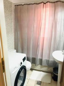 lavatrice in bagno con servizi igienici di Aegina luxury apartments a Città di Egina