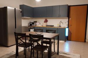 kuchnia ze stołem, krzesłami i lodówką w obiekcie Aegina luxury apartments w mieście Egina