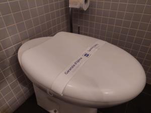 a white toilet seat with a sticker on it in a bathroom at Green Pepper Apartment in Florence in Florence