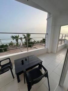 Cette chambre dispose d'un balcon avec une table et une chaise. dans l'établissement Superbe appartement pied et vue sur mer, à Taghazout