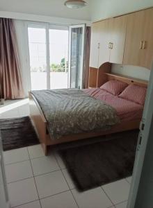 une chambre avec un lit et une grande fenêtre dans l'établissement Superbe appartement pied et vue sur mer, à Taghazout