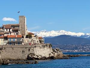a building on top of a cliff in the water at Palais Albert . 2-Bedroom Apartment -Ponteil Beach in Antibes