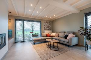 uma sala de estar com um sofá e uma televisão em Vakantiewoning De Bles em Avelgem