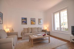 a living room with a couch and a coffee table at Palais Albert . 2-Bedroom Apartment -Ponteil Beach in Antibes