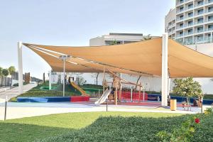 Luxury apartment in Yas Island في أبوظبي: مظلة مع ملعب أمام المبنى