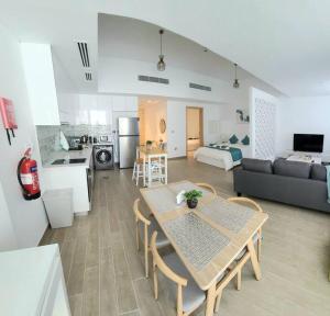 uma cozinha e uma sala de estar com uma mesa e um sofá em Luxury apartment in Yas Island em Abu Dhabi