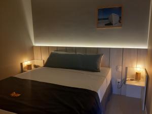Un dormitorio con una cama con dos luces. en Flat Samba en Cabo Frío