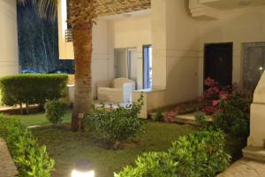 een huis met een palmboom en een bank in een tuin bij Sharm El Sheikh flat 2 bedrooms in front of pool in Sharm El Sheikh