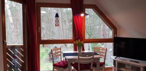 uma sala de jantar com uma mesa em frente a uma janela em Ferienhaus Knopf -direkt am Küstenwald em Zinnowitz