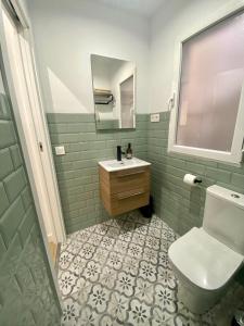La salle de bains est pourvue de toilettes, d'un lavabo et d'un miroir. dans l'établissement Apartamento La Muralla, à Talavera de la Reina