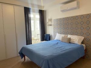 a bedroom with a bed with a blue comforter at Cozy 2 bedroom Apartment near Seafront in Il-Gżira