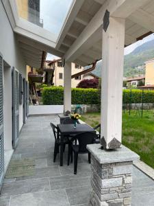 a patio with a table and chairs on a porch at Casa Tortora in Gravedona