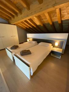 2 letti in una camera con soffitti in legno di Marenca Residence a Cannobio