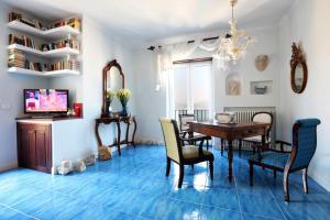 a dining room with a table and chairs on a blue floor at Di sole e d’azzurro - sea view in Gaeta