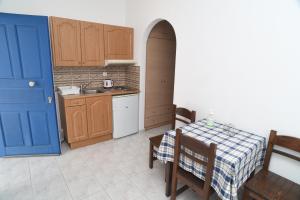 a kitchen with a table and a blue door at Joanna Apartments in Mikri Vigla
