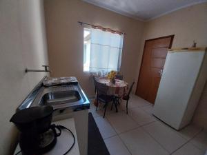 La cuisine est équipée d'un évier, d'une table et d'un réfrigérateur. dans l'établissement Projetada com Joao, à Campos dos Goytacazes