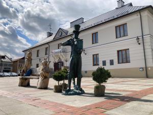 a statue of a woman standing in front of a building at Apartament Villa Olivia in Szczebrzeszyn