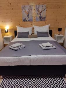 um quarto com uma cama grande com duas toalhas em WALDHAUS HIRSCH Bungalow only for you self check in em Pörtschach am Wörthersee