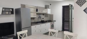 a kitchen with white cabinets and a table and chairs at Villa swamy in Bisceglie