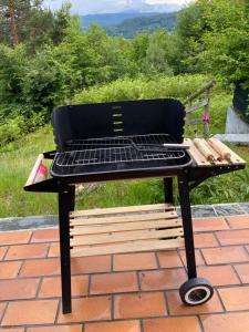 a barbecue grill sitting on top of a brick patio at WALDHAUS HIRSCH Bungalow only for you self check in in Pörtschach am Wörthersee
