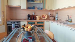 una cocina con una mesa de cristal con un bol de fruta en Evaggelia's Seaside Boutique Apartment, en Iräon