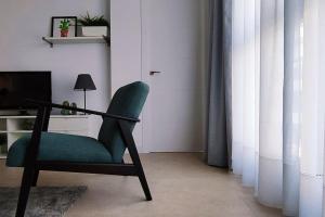 uma cadeira verde numa sala de estar com televisão em Céntrico apartamento con vistas em Santa Cruz de Tenerife