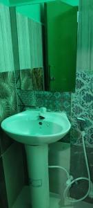 bagno con lavandino bianco e specchio di faTuur Inn a Città di Malé