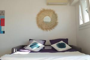 um quarto com uma cama com almofadas e um espelho em Centre et plage tout à pied échappée mer em Cannes