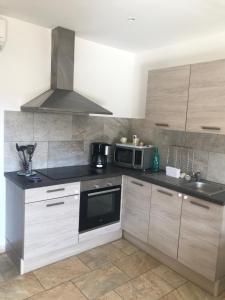 kuchnia z kuchenką i mikrofalówką w obiekcie Mini villa proche des plus belles plages w mieście Porto-Vecchio