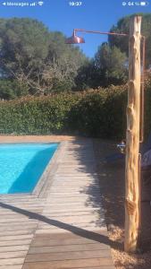 drewniany chodnik obok basenu z oświetleniem w obiekcie Mini villa proche des plus belles plages w mieście Porto-Vecchio +5 zdjęć