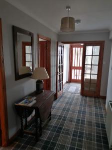 a room with a table with a lamp on it at Brackenbrae Holiday Cottage in Acharacle