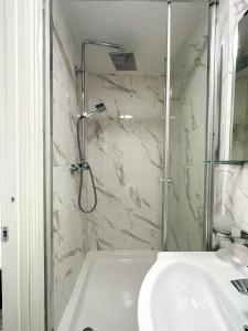 biała łazienka z prysznicem i umywalką w obiekcie the upper floor w mieście Croydon