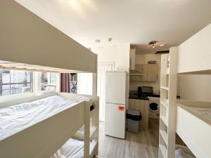 a bedroom with a bunk bed and a kitchen at the upper floor in Croydon