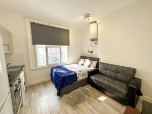 a small bedroom with a bed and a couch at the upper floor in Croydon