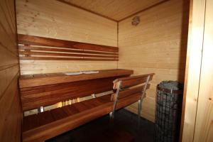 a wooden sauna with a wooden bench in it at Huoneistomajoitus Tupa,LaatuLomat in Juva
