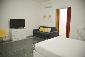 a bedroom with a bed and a couch and a television at La Casa di Eva in Brindisi