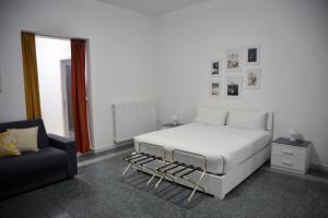 a bedroom with a white bed and a couch at La Casa di Eva in Brindisi