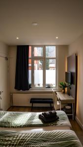 a bedroom with a bed and a desk and a window at Inn den Acht Venlo in Venlo
