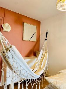 a hammock hanging in a room with a clock on the wall at Maisonnette climatisée à 35m de la plage de La Capte Hyères in Hyères