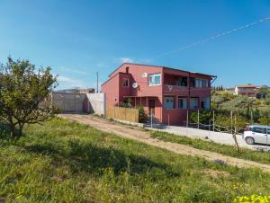 une maison rouge sur le côté d'une route dans l'établissement Carlitos, à Realmonte