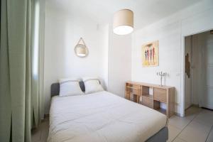 a white bedroom with a bed and a sink at Appartement tout équipé balcon 4 pers St Charles in Marseille