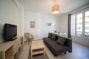a living room with a couch and a tv at Appartement tout équipé balcon 4 pers St Charles in Marseille