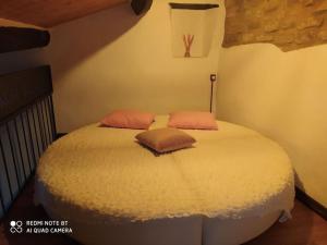 1 dormitorio con 1 cama con 2 almohadas en Ca' Marcella terra cielo tre livelli con soppalco, en Montetiffi