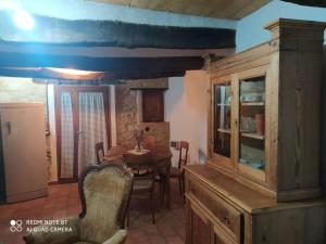 comedor con mesa y armario de madera en Ca' Marcella terra cielo tre livelli con soppalco, en Montetiffi