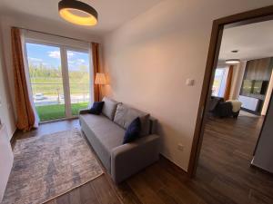 Una sala de estar con un sofá y una ventana grande. en Dandelion Royal Homes, en Keszthely 38 fotos más
