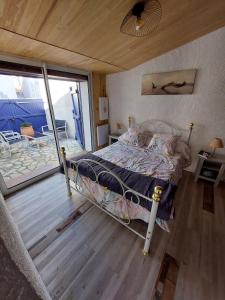 ein Schlafzimmer mit einem Bett und einem Balkon in der Unterkunft Maison typique oléronaise in Le Château-dʼOléron