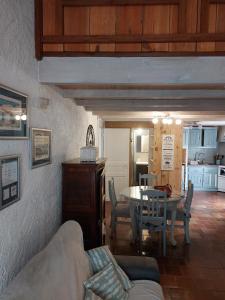 ein Wohnzimmer mit einem Tisch und einer Küche in der Unterkunft Maison typique oléronaise in Le Château-dʼOléron